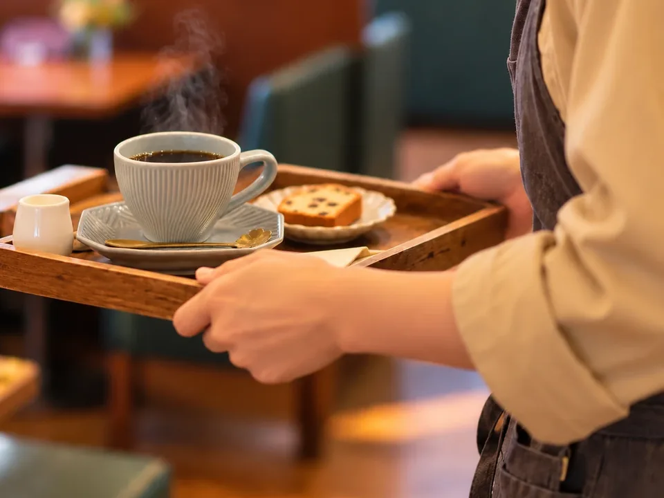 トレーでコーヒーを運ぶ手元